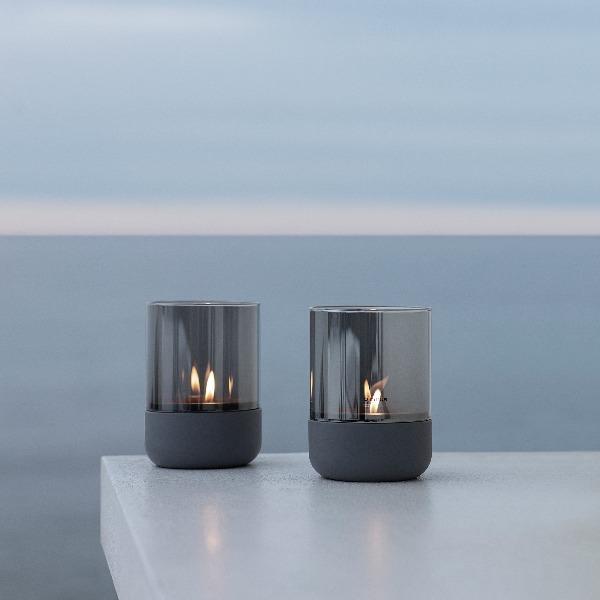 Oceanview with two hurricane lamps with glass wind screens on a white table