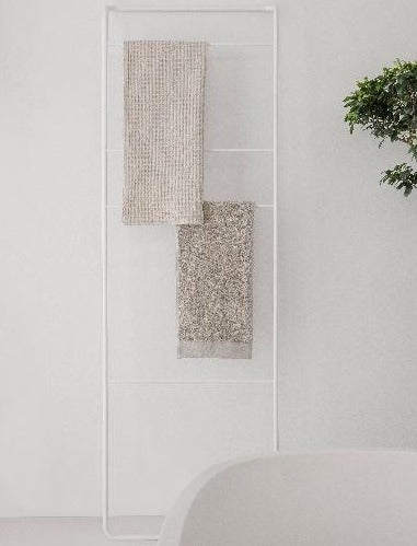 Simplistic white towel ladder in a minimalist modern bathroom