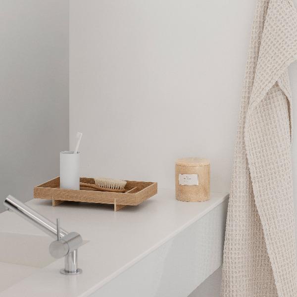 white bathroom counter with ABENTO wood tray by blomus