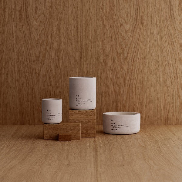 Wood blocks with FRAGA concrete candles placed on top against a wood background