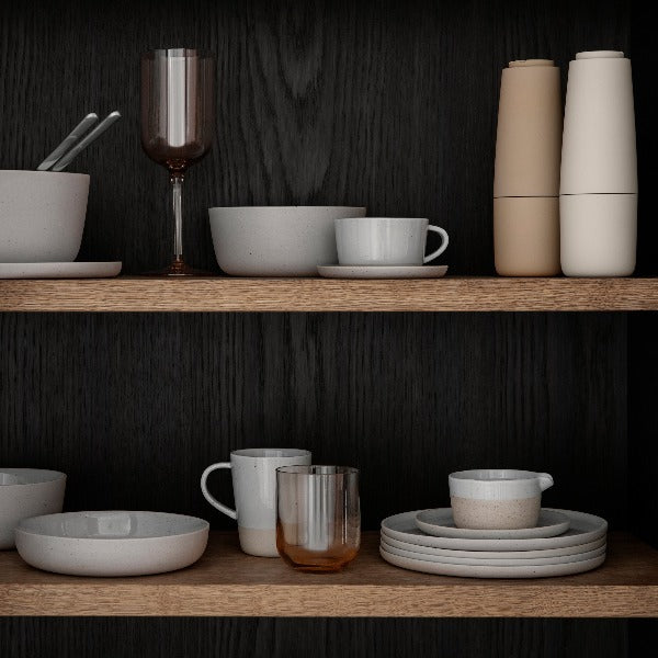 dimly lit wood shelves with dishware and SALPI salt and pepper grinder set