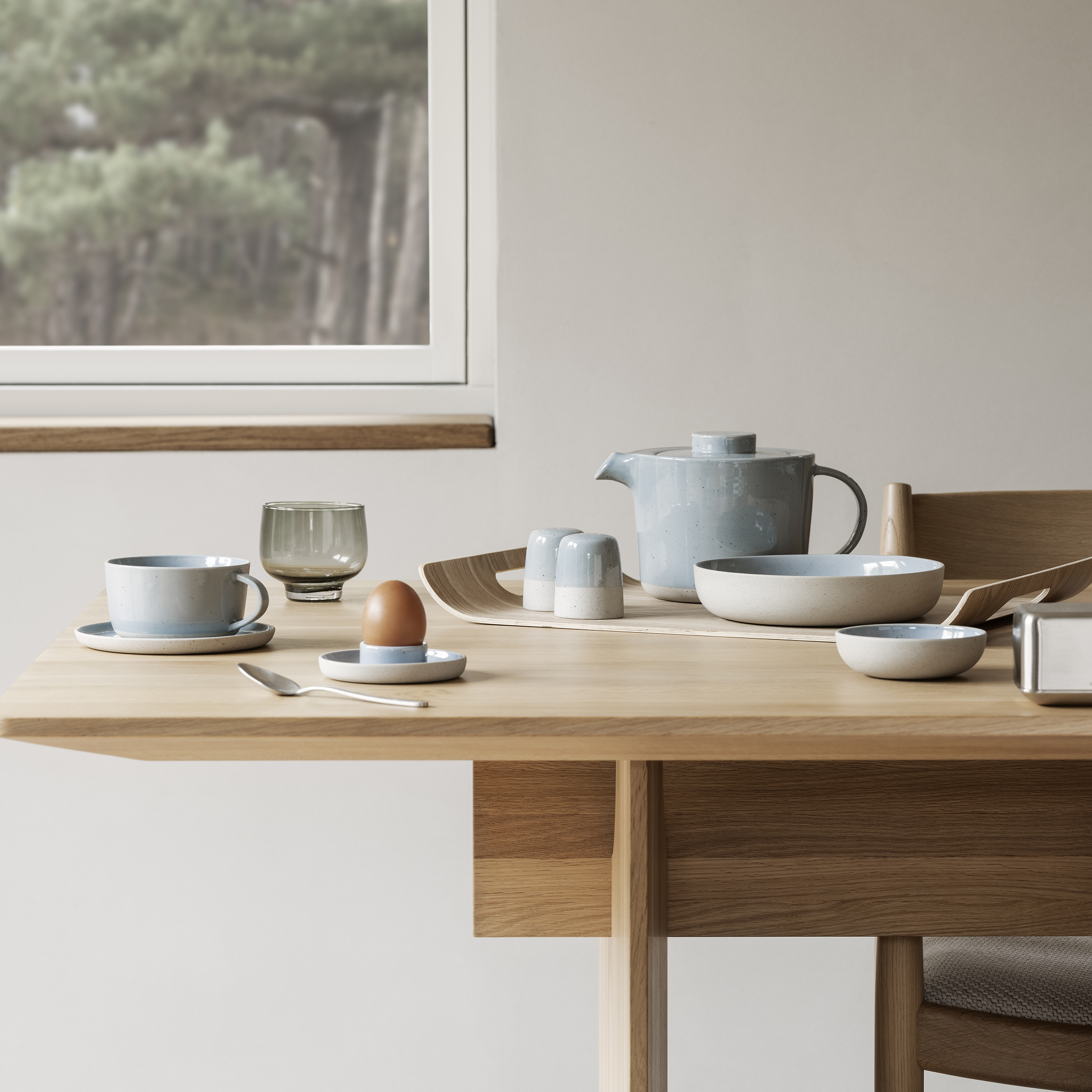 modern dining table in front of window with breakfast ceramic tableware from SABLO by blomus