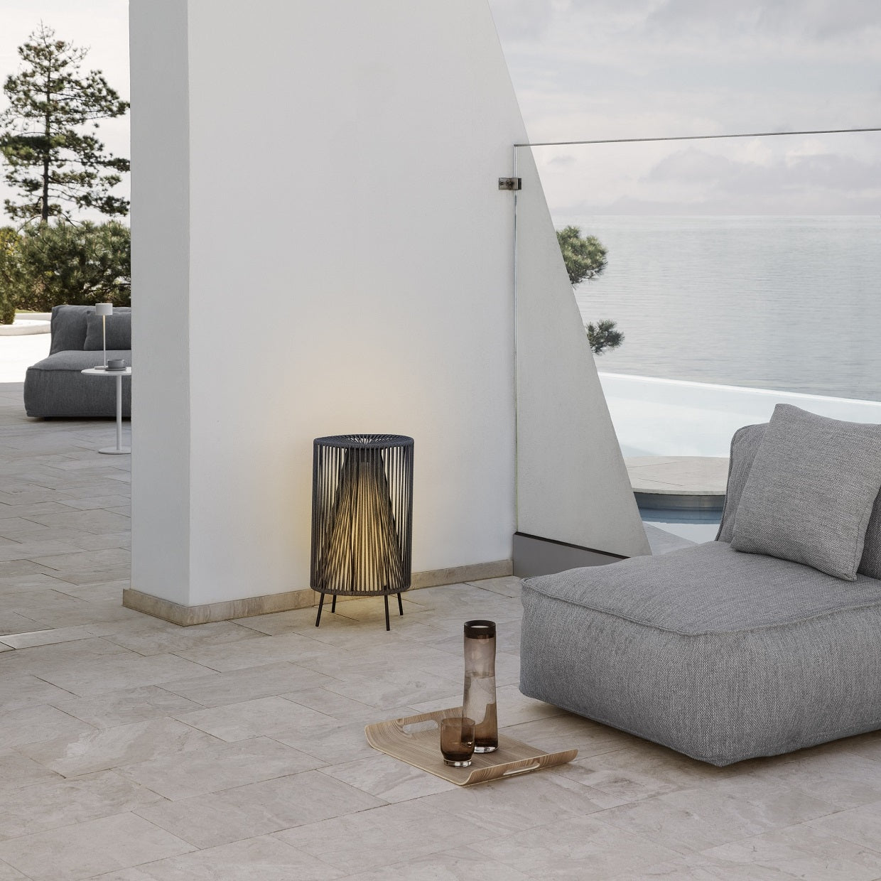 Modern outdoor seating next to large body of water with warm glow LED rope light
