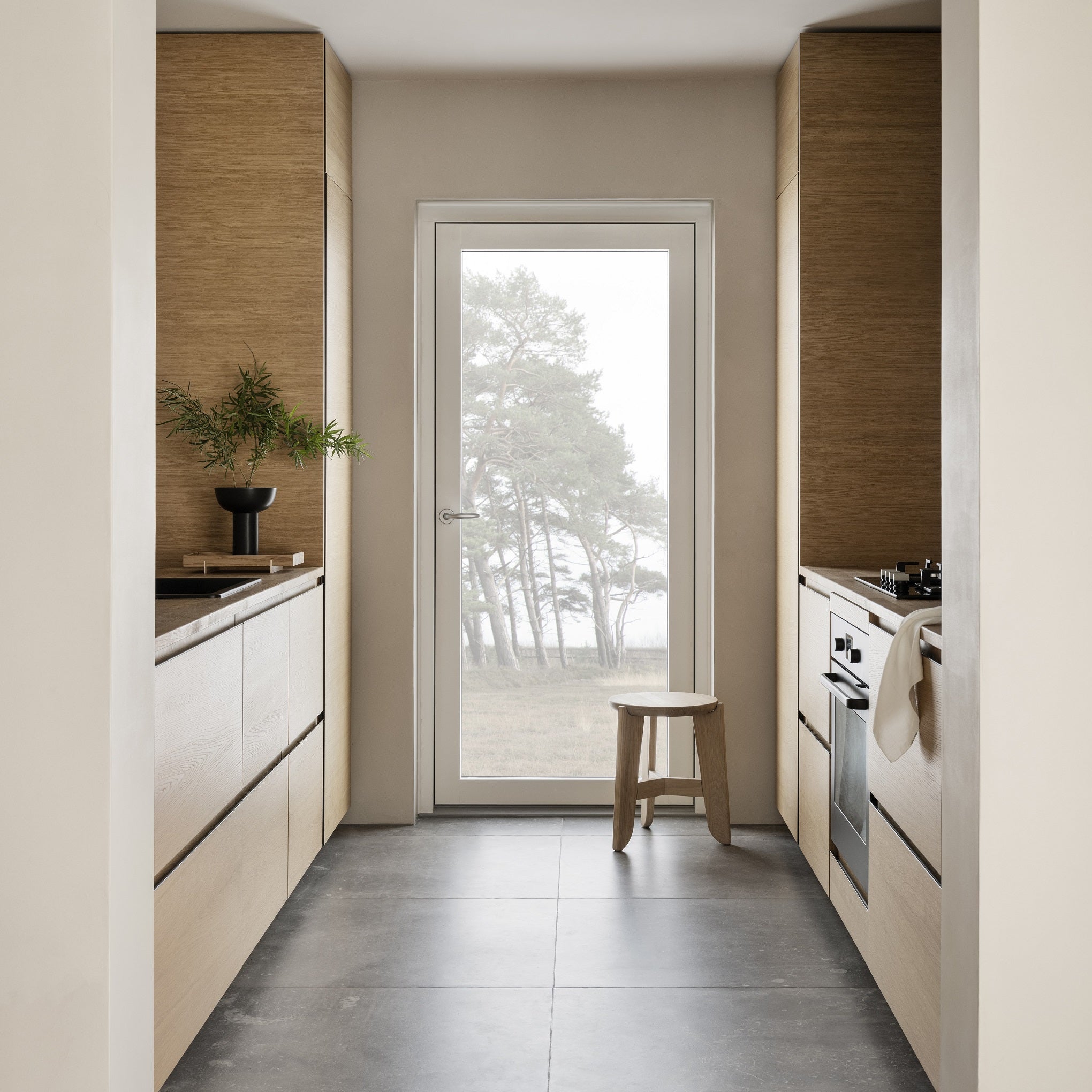 simple galley kitchen with ELI oak stool by door