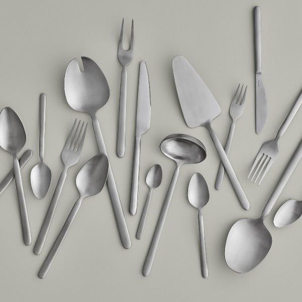 blomus STELLA stainless steel flatware set against a minimalist grey background