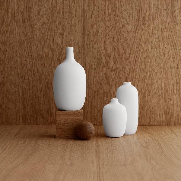 beautiful wood grain background with CEOLA white porcelain vases displayed on blocks