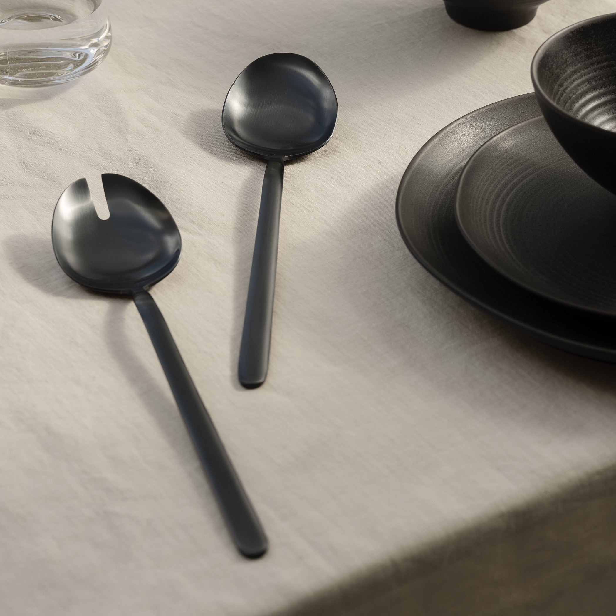 blomus STELLA black stainless salad servers in an elegant table setting with table cloth