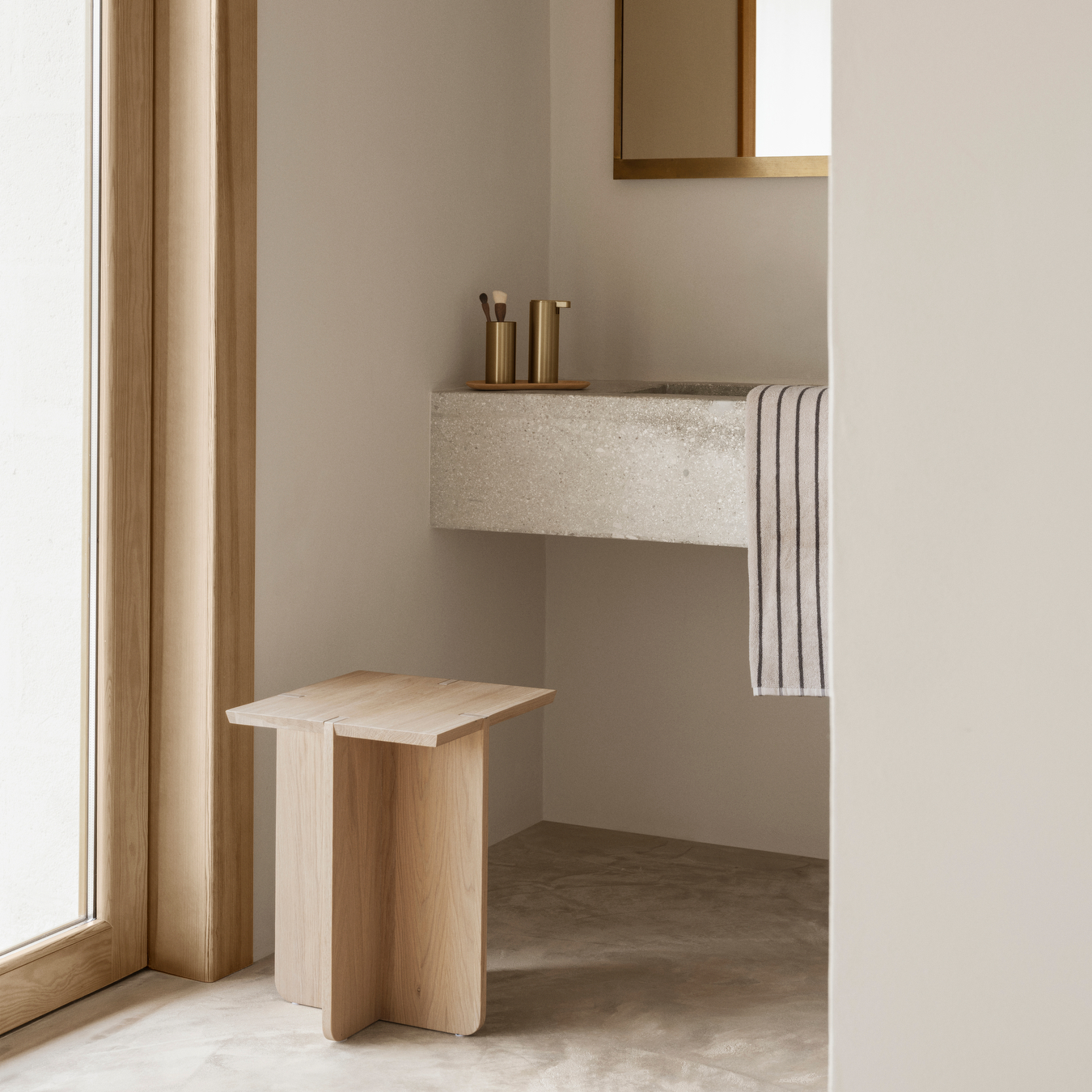 Minimalist bathroom with ENGAWA Oak Stool, concrete sink, MODO Bathroom Accessories and towel.