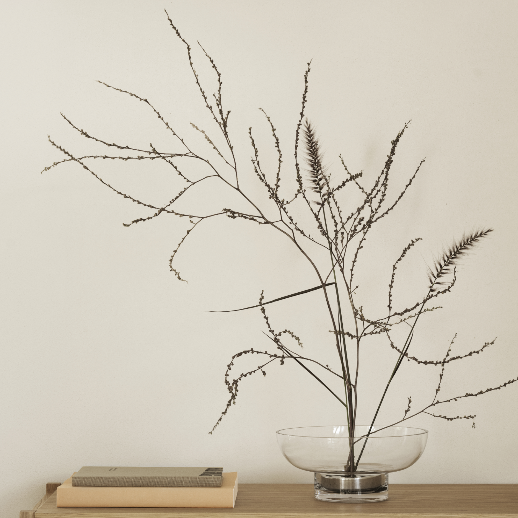 MIYABI Glass Vase containing branches sitting on a wood shelf with books placed beside it.