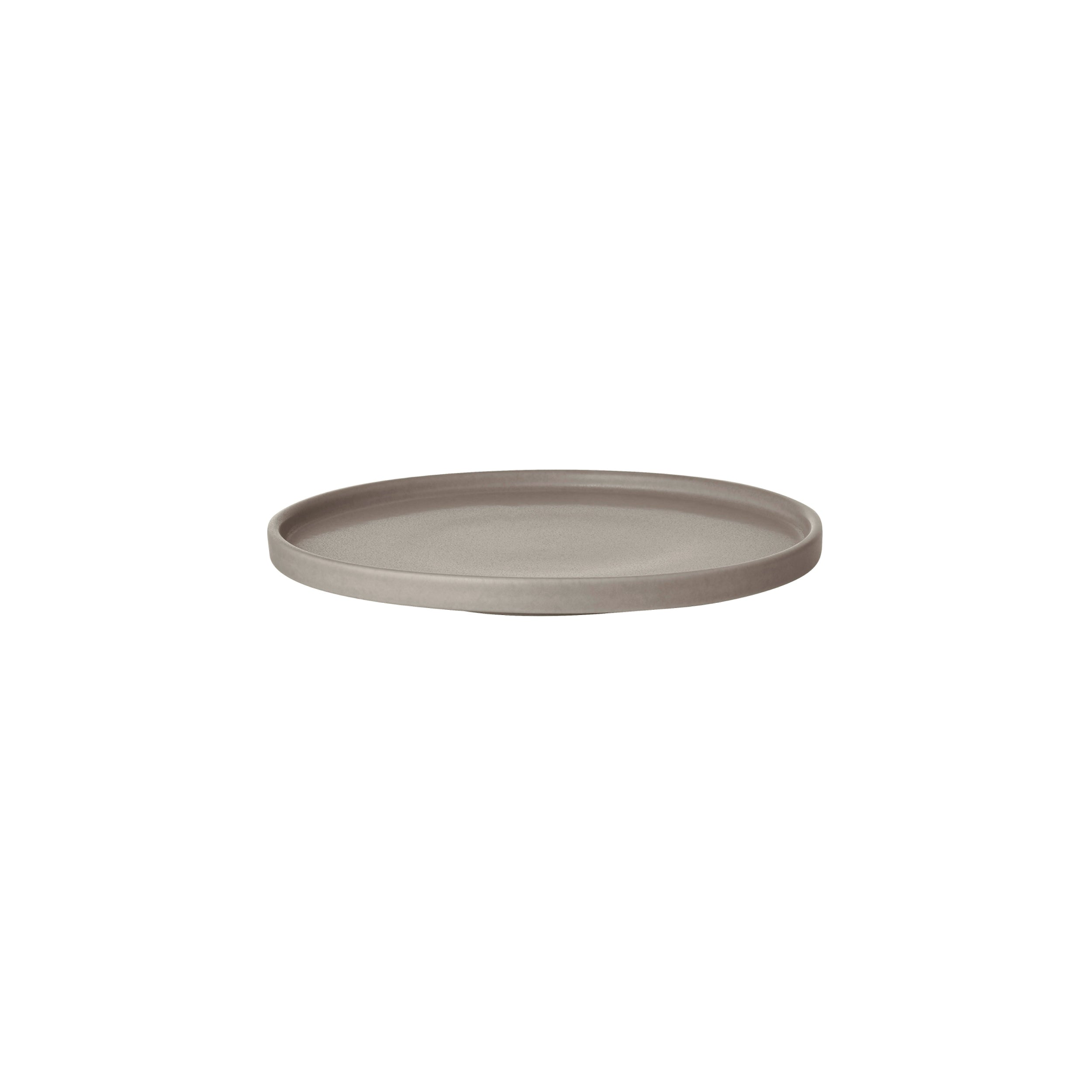 Round beige ceramic plate on a white background