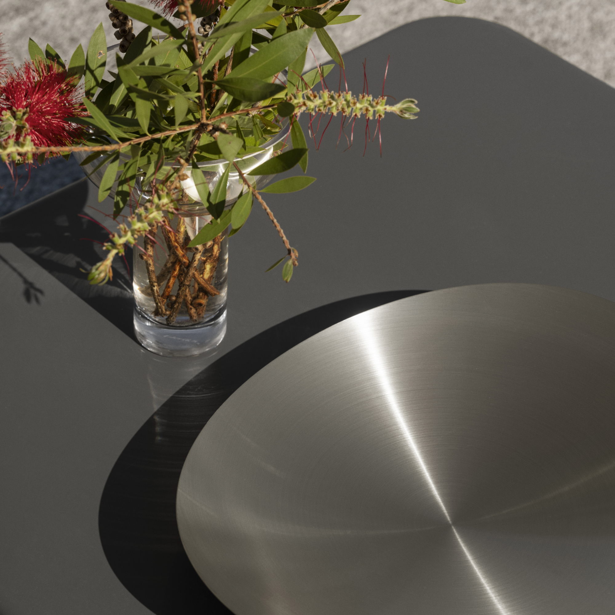 MIYABI Glass Vase on an outdoor table filled with flowers beside an ONDEA Bowl.