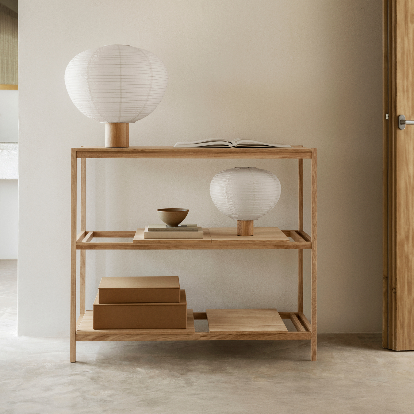 SAHLA Storage Boxes on SUKOYA Shelves with lamps, books and dishes.