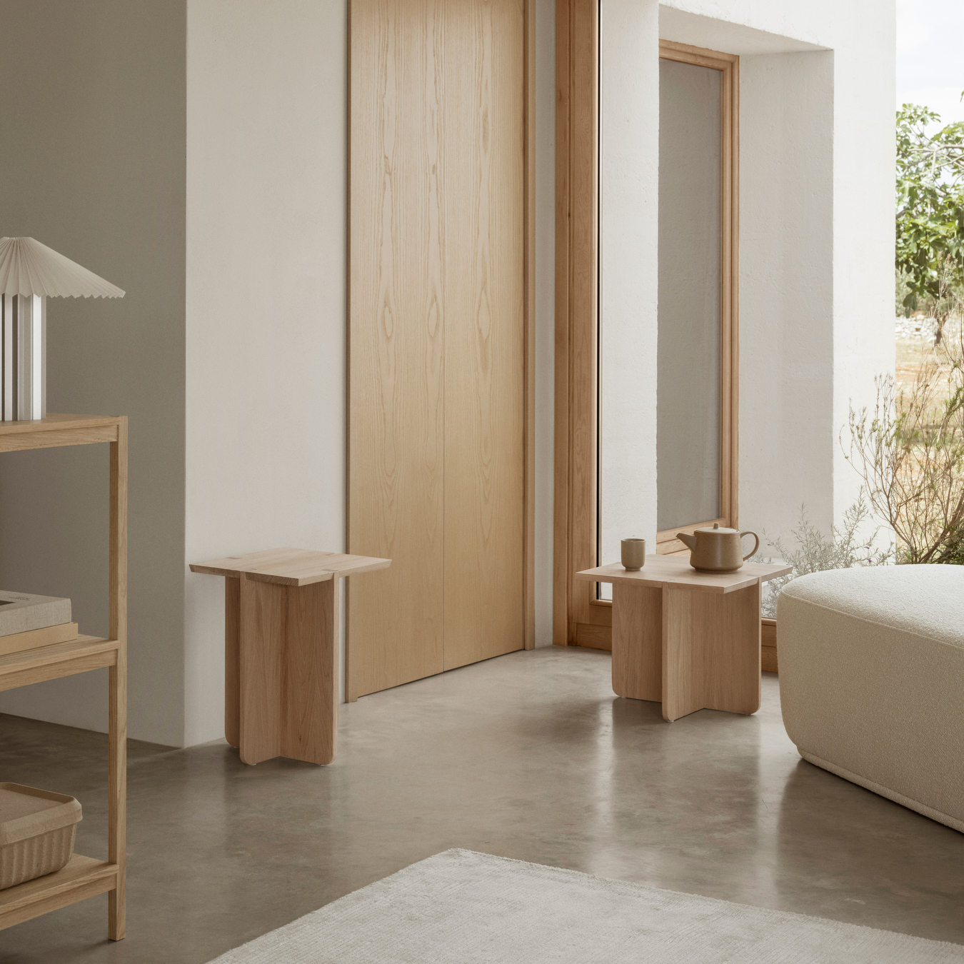 ENGAWA Stool and Side Table shown in a neutral room with other furnishings and a large window showing outdoor plants.