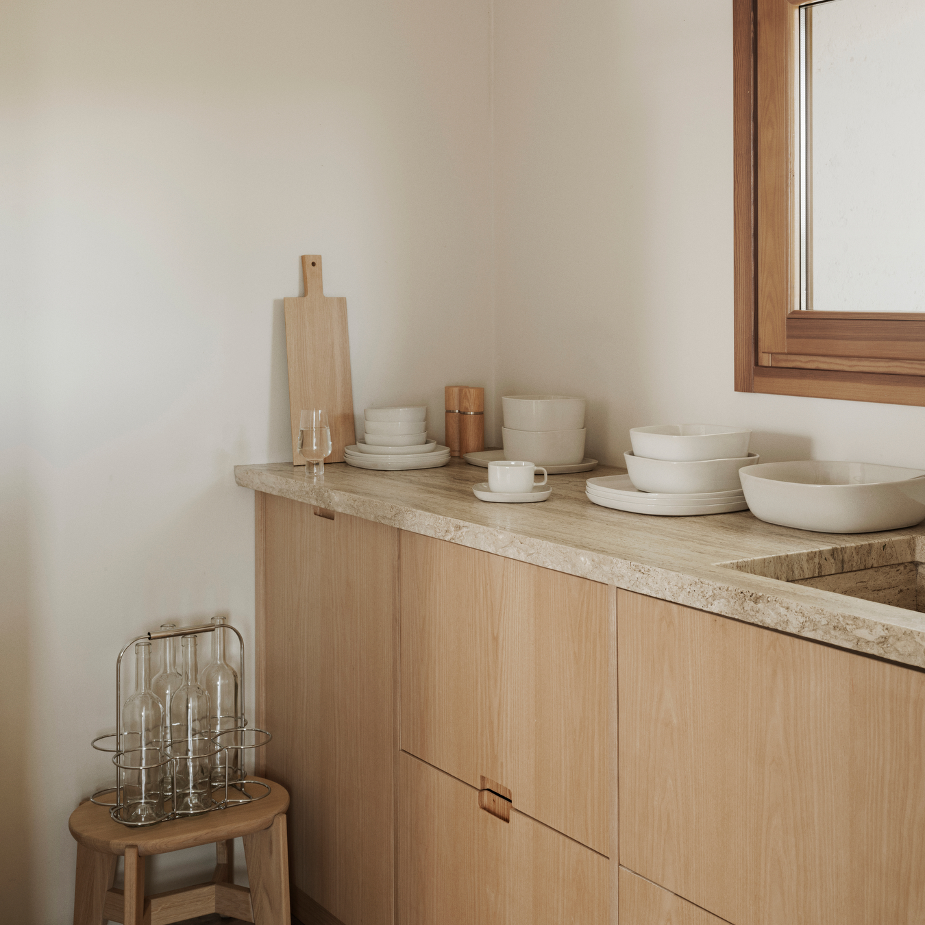 Kitchen Counter placed with VAHLO Moonbeam assorted dishes. ELI Stool to the side with wire bottle holder sitting atop.