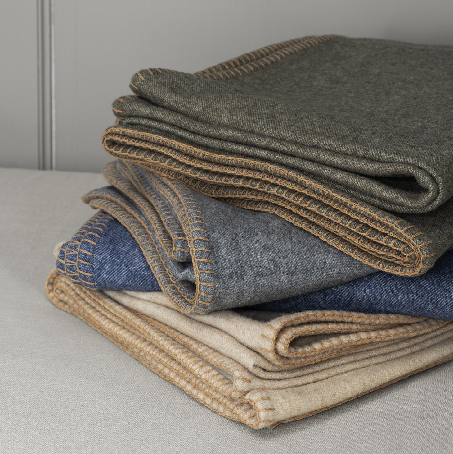 casually folded wool throw blankets in multiple colors
