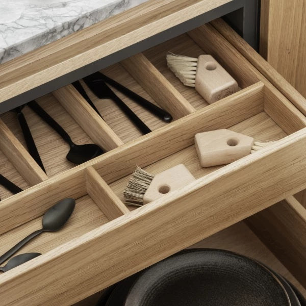 neatly arranged kitchen drawer with natural bristle wood handled brushes by blomus AVES