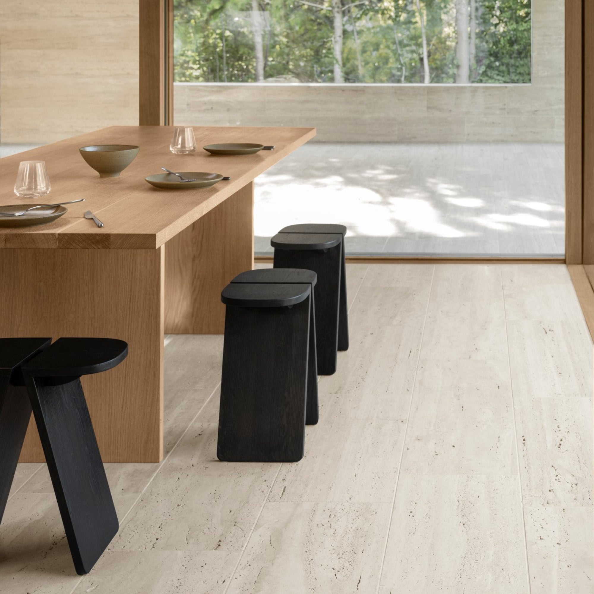 blomus AVIO solid oak stool in black around a modern dining table with Asian aesthetic