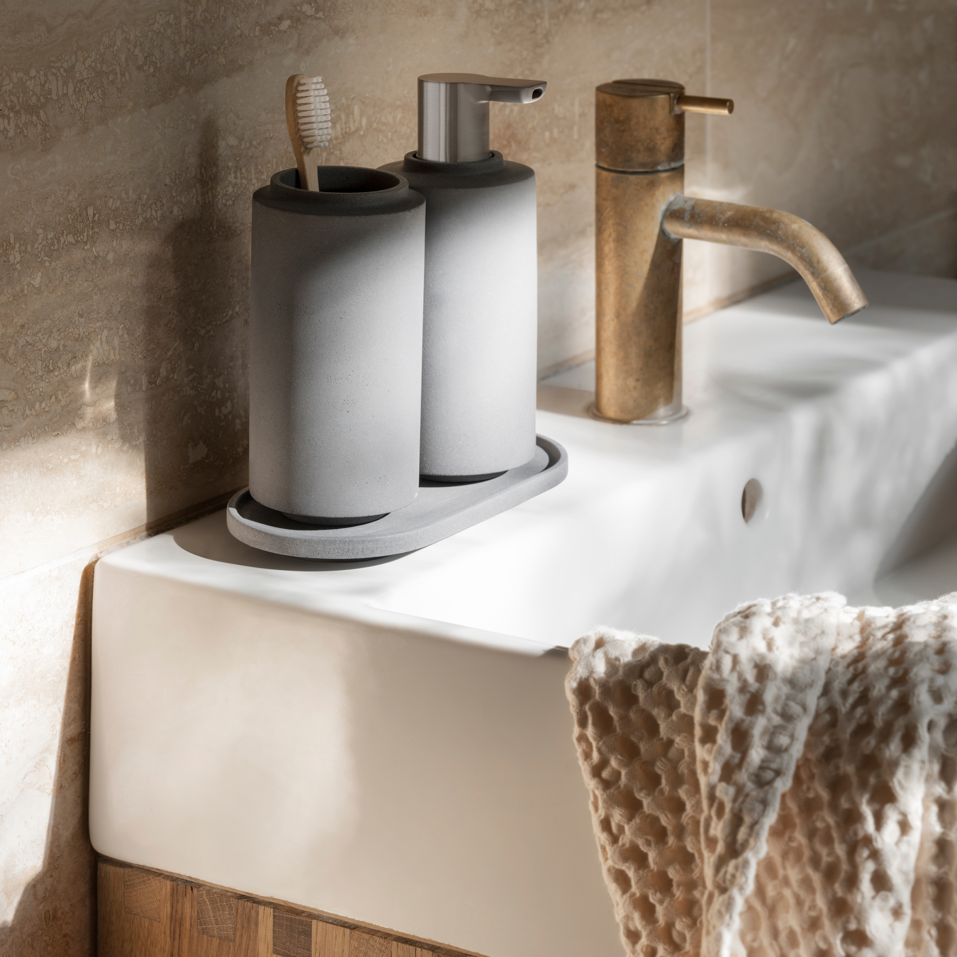 Modern Industrial feel bathroom sink with marble backsplash showcasing blomus CRETO concrete bath accessories