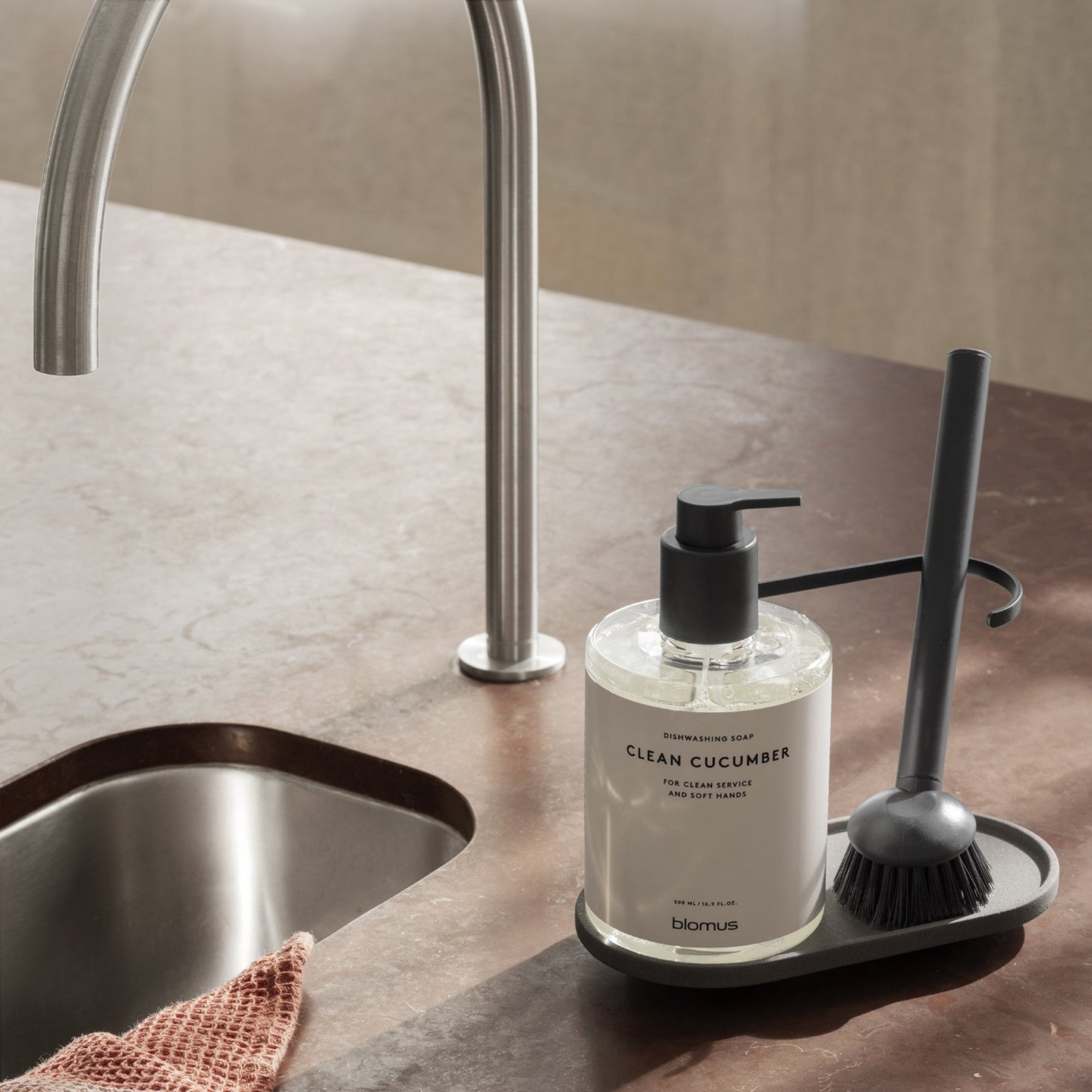 blomus DHUVA ceramic kitchen sink organizer on red marble countertop by sink
