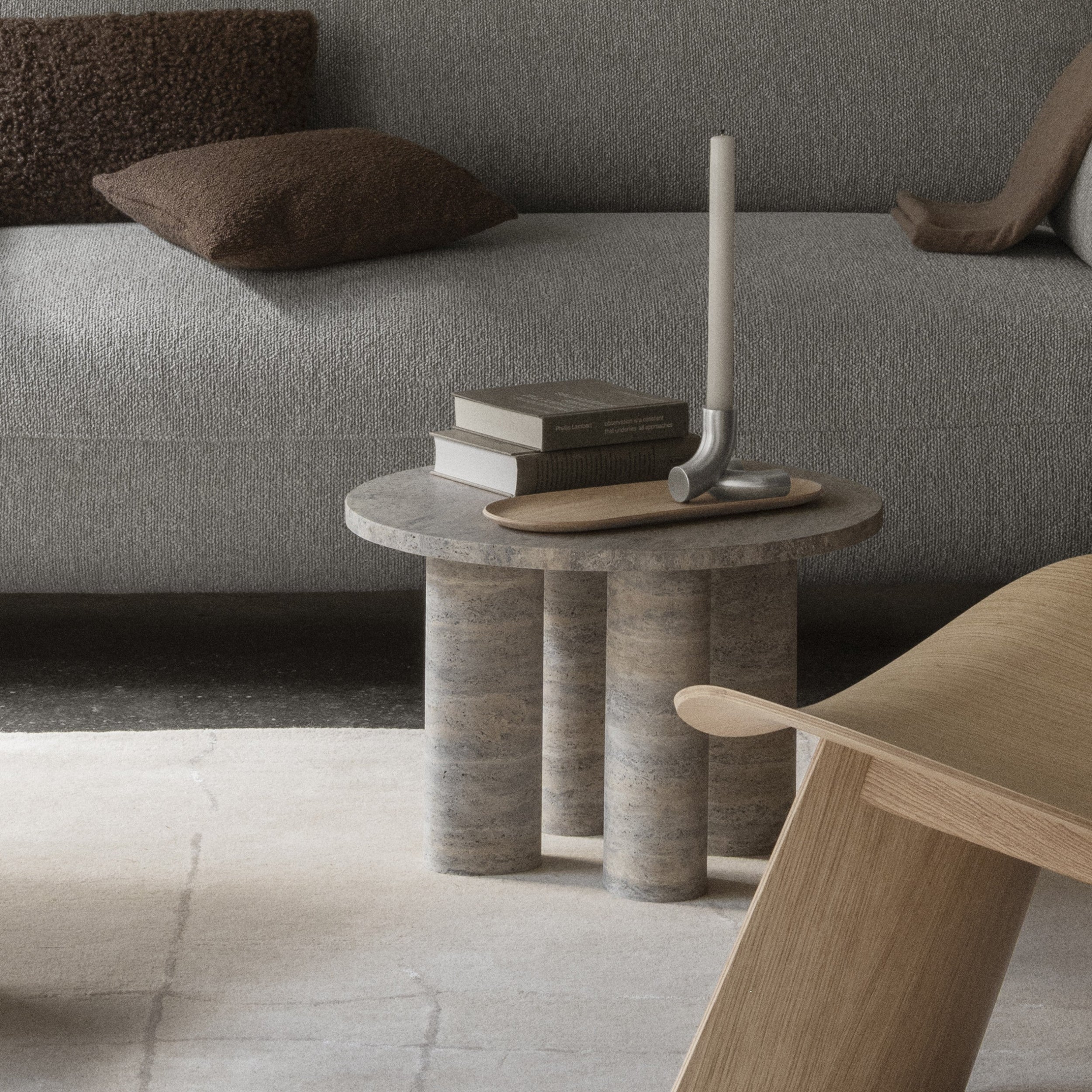 Modern living room with a gray sofa, round stone table, and wooden coffee table holding DOODLE Candle Holder.