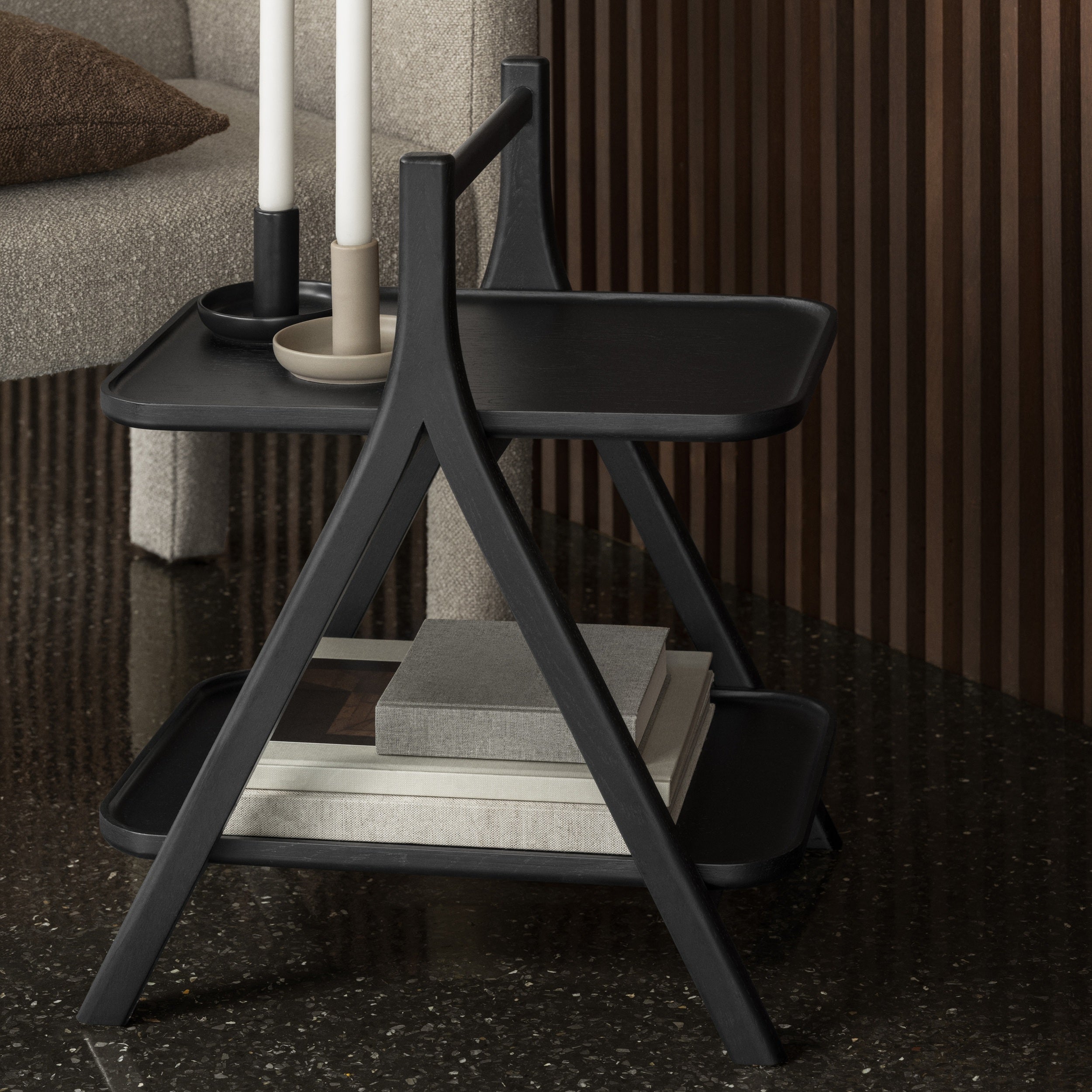 Black wooden side table with shelves in a living room setting