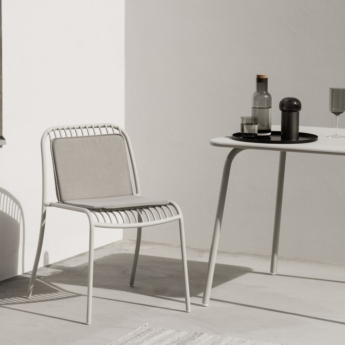 blomus FUUMI smoke colored glassware displayed in a minimalist outdoor seating area