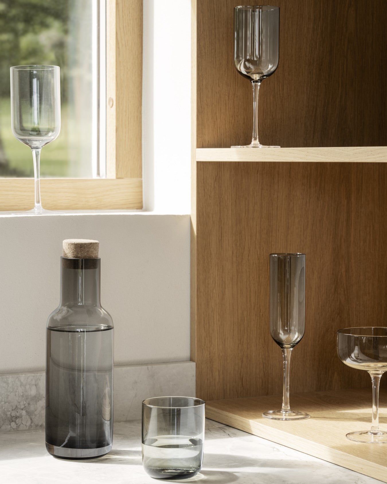 minimalist kitchen counter displaying blomus FUUMI collection of mouth blown glassware