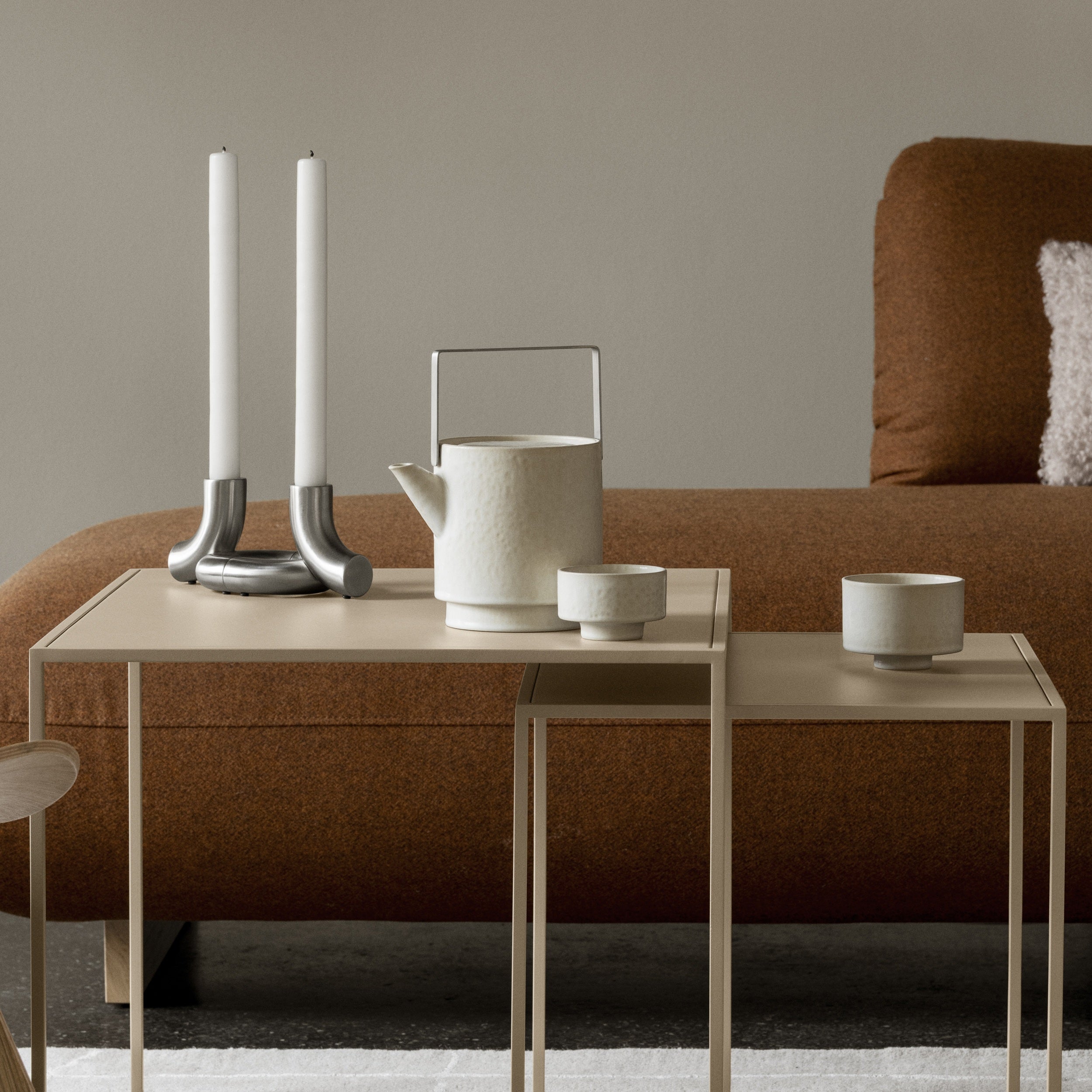 Tea set on nesting table with a brown sofa in the background