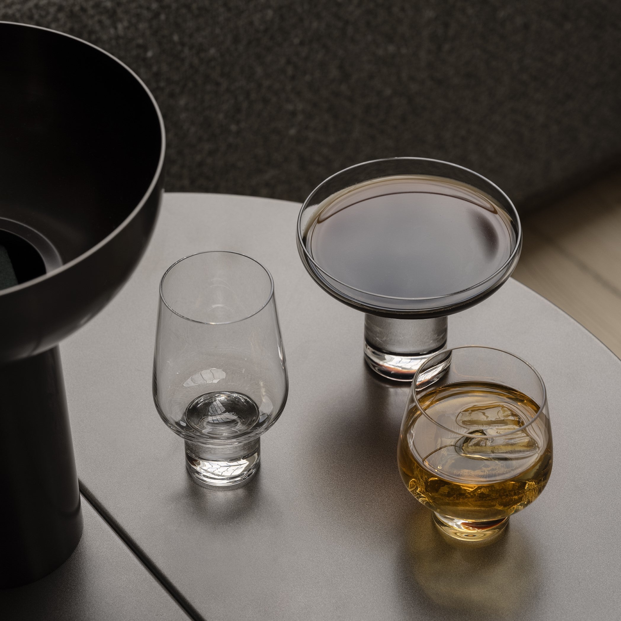 three styles of KOYOI modern cocktail glasses on a side table in a minimalist living area