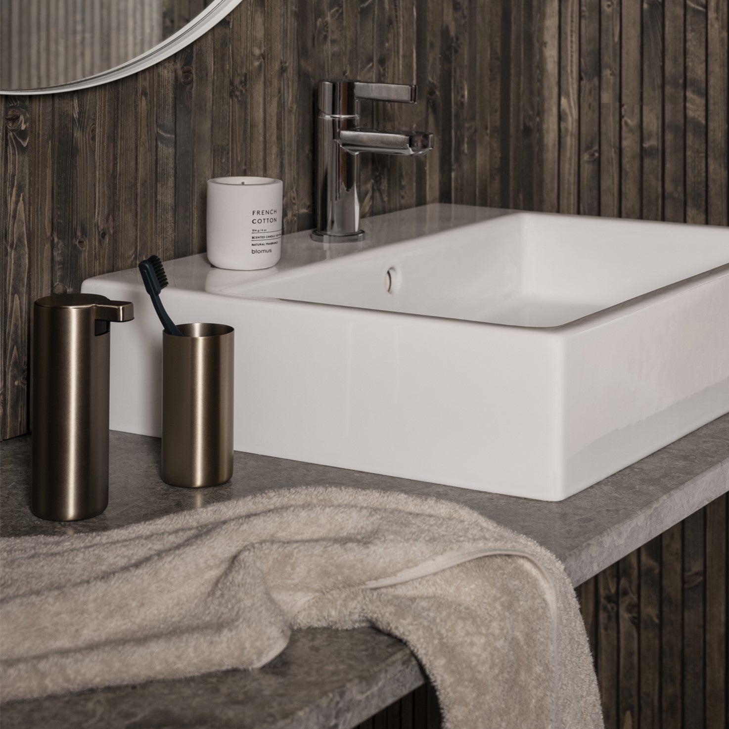 Bathroom sink with MODO Bathroom Accessories, candle and RIVA Towel.