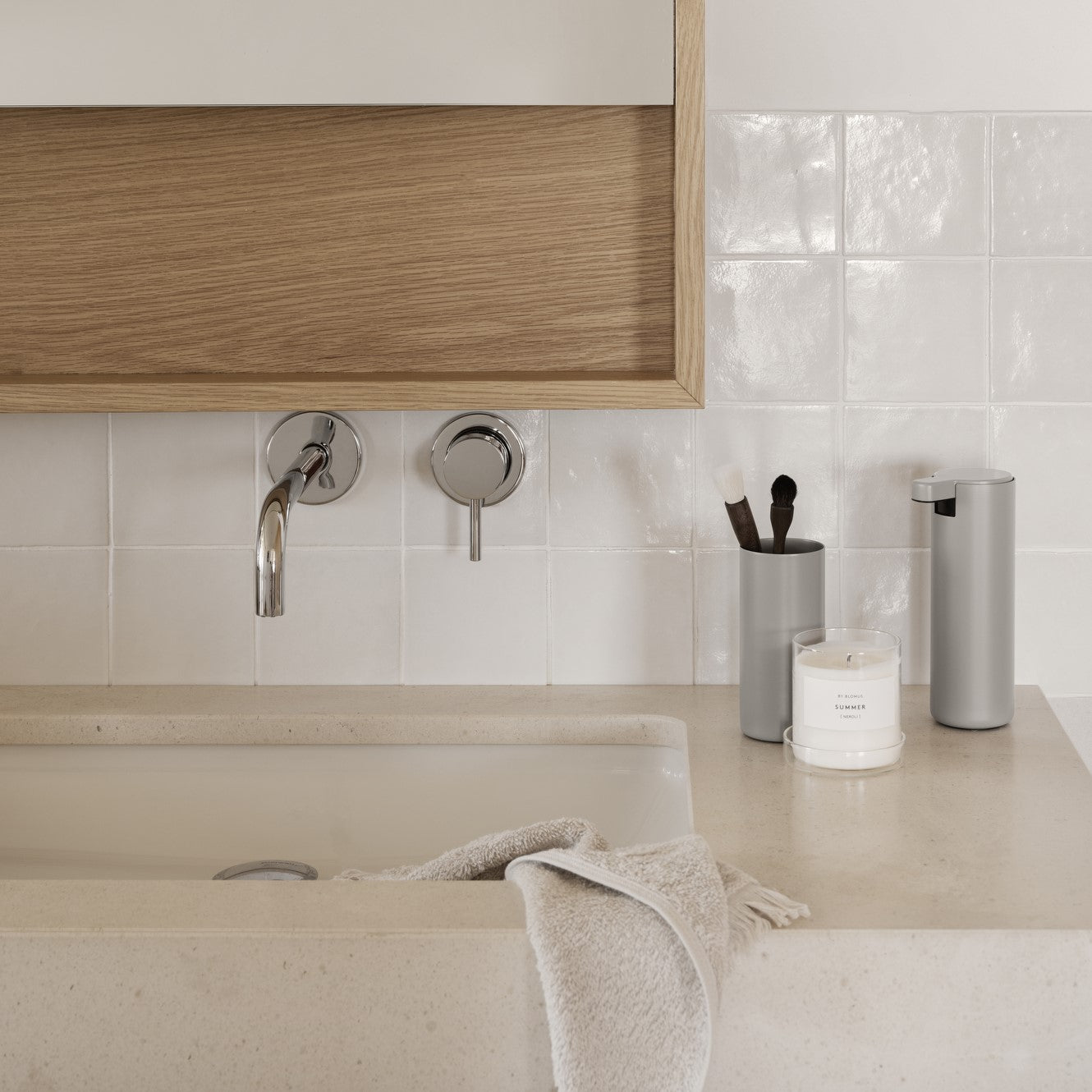 Minimalist bathroom sink with modern grey bathroom tumbler and soap dispenser by blomus