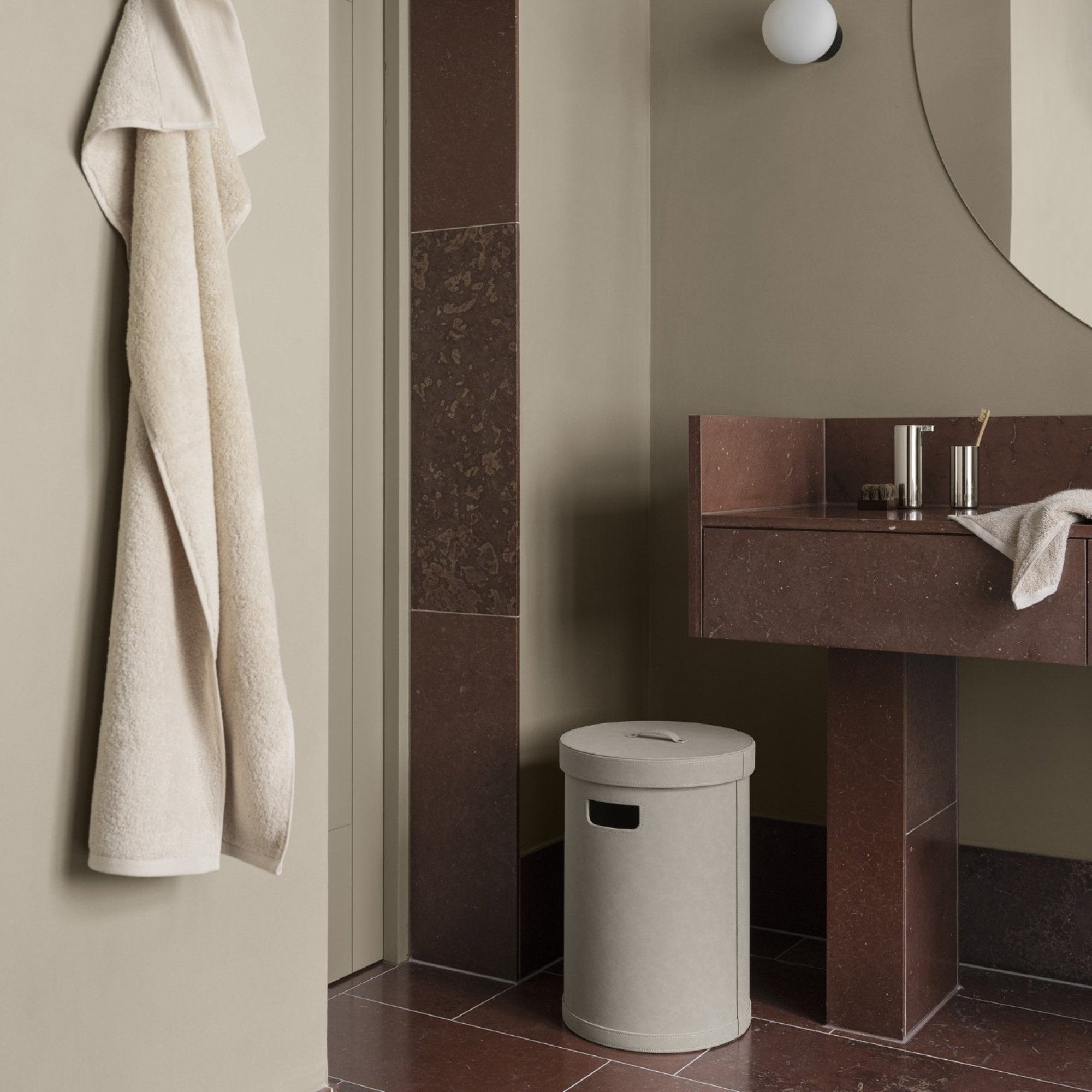 Decorative storage bin with lid in a bathroom with red marble floors 