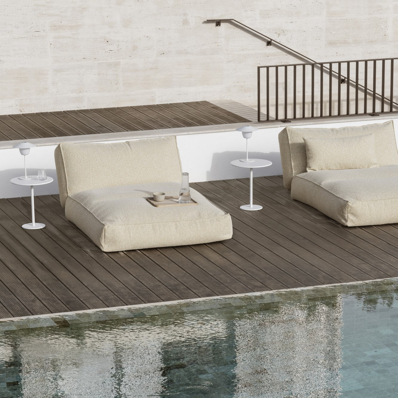 Poolside lounge area with Outdoor LED lamps on side tables next to loungers