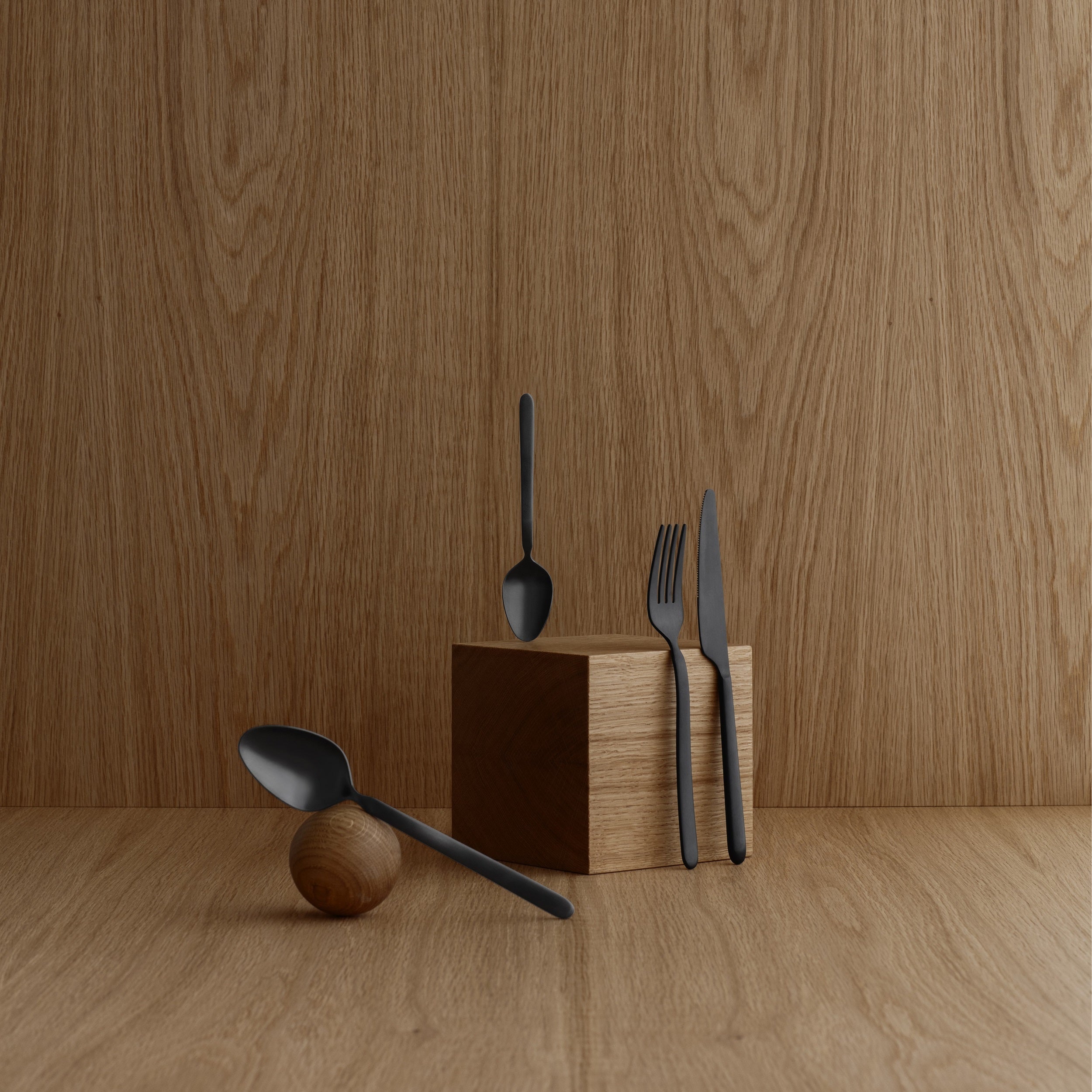 blomus STELLA sleek black cutlery arranged on wooden blocks with a clean minimal aesthetic
