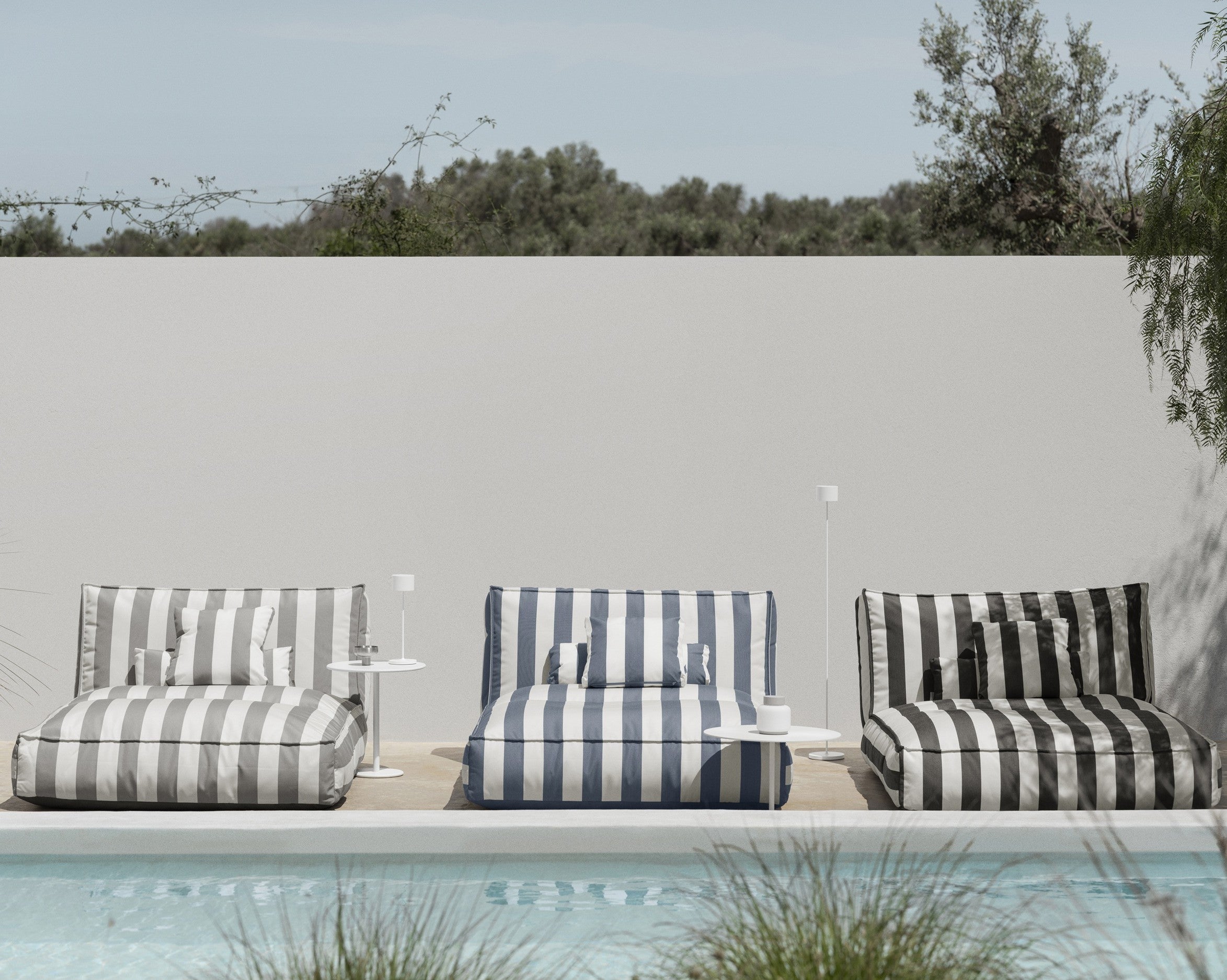 Striped outdoor chairs by a pool with a neutral background