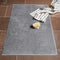 TUYO Bathmat sitting on tile floor with towel and bathing brush.