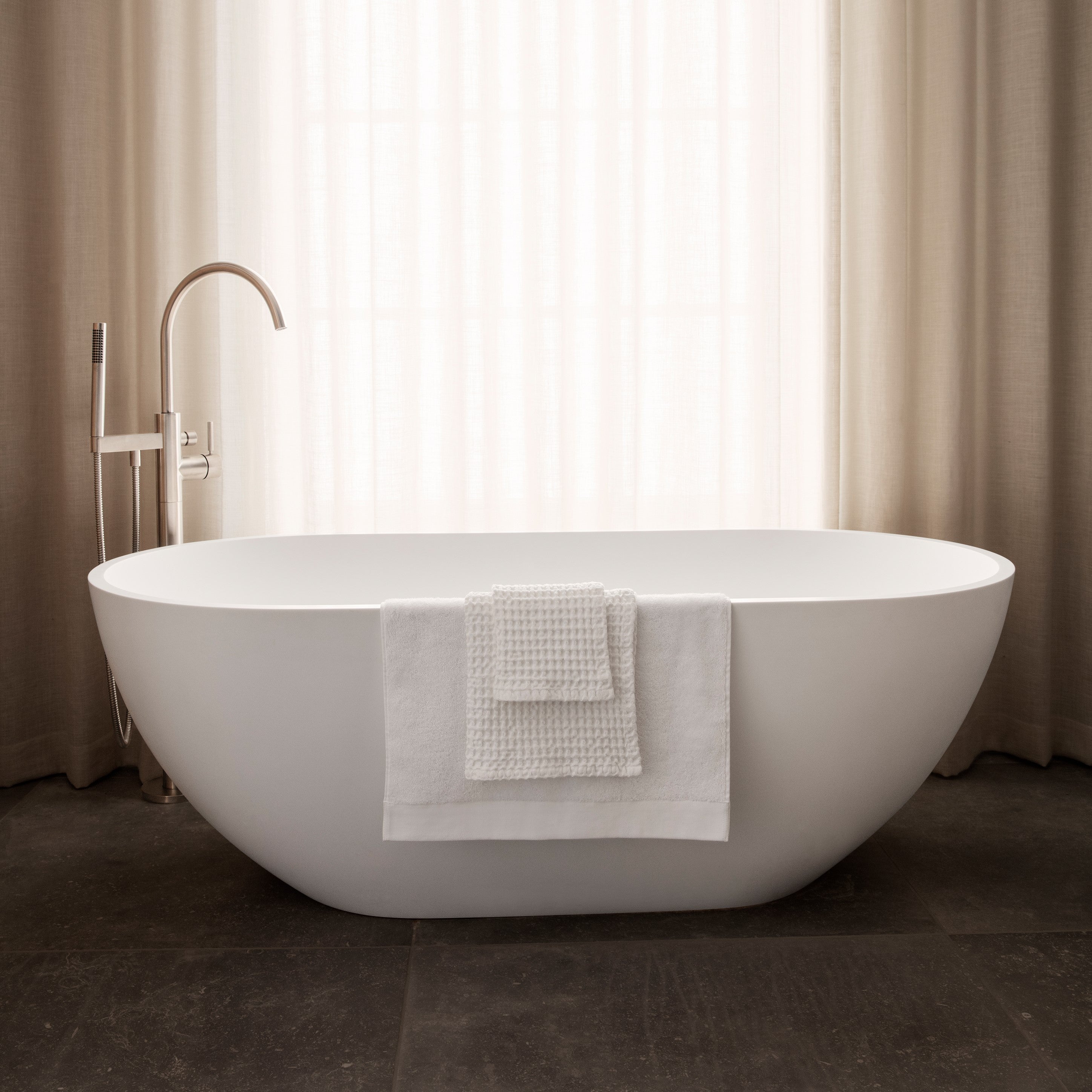 Elegant bathtub with waffle towels folded over side