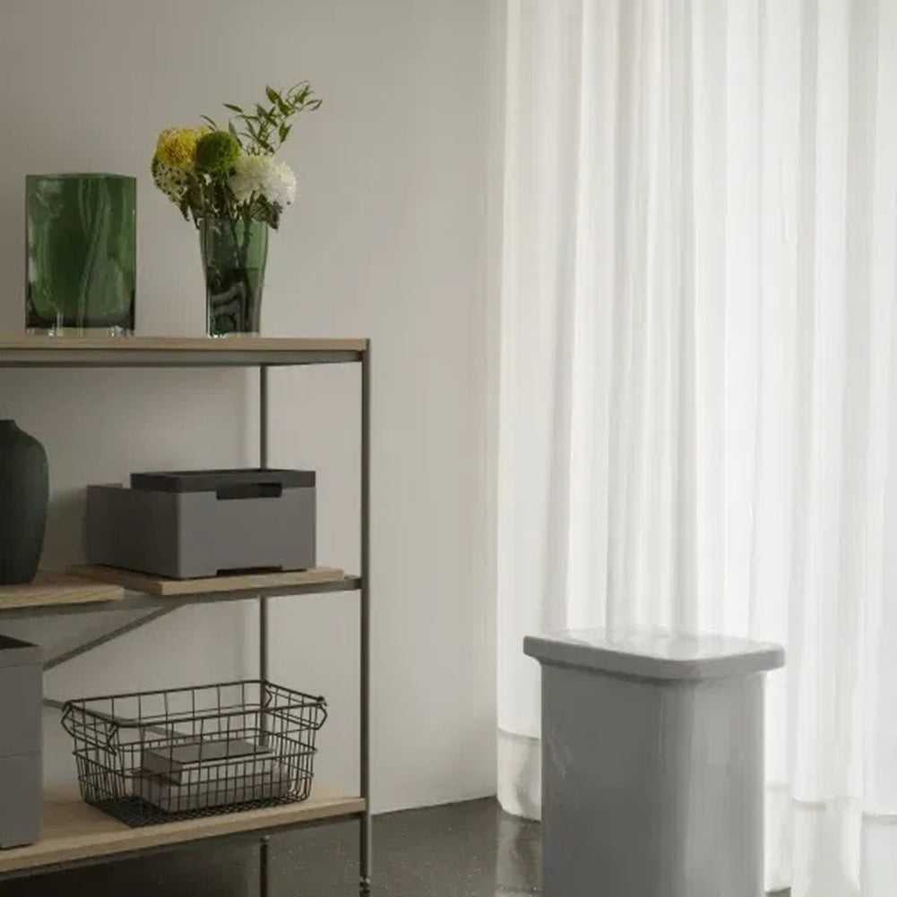 Modern interior with a shelf and decorative items next to a curtain.