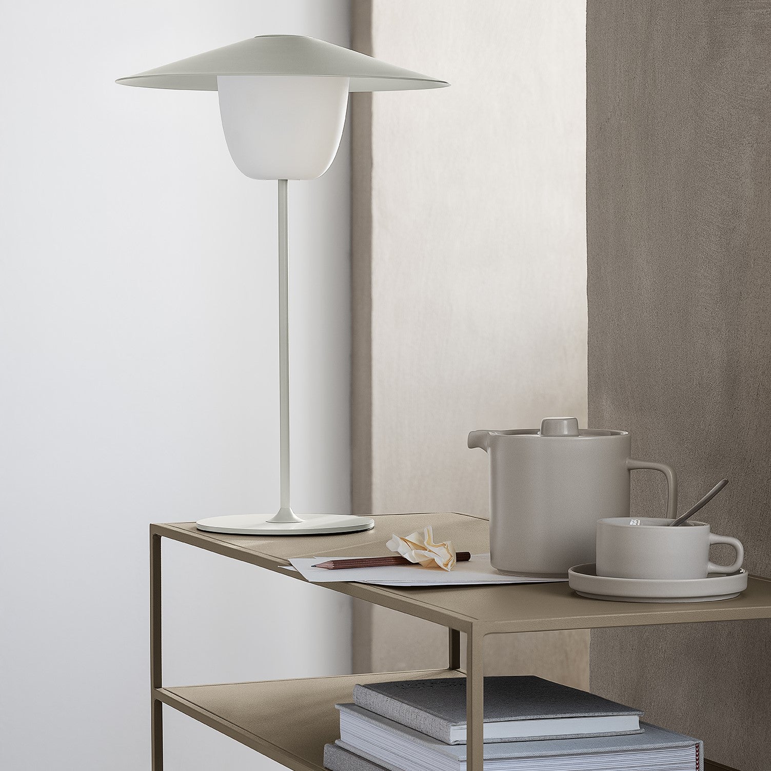 blomus PILAR ceramic tea set with teapot and teacup in soft matte moonbeam finish atop a simple side table near a window