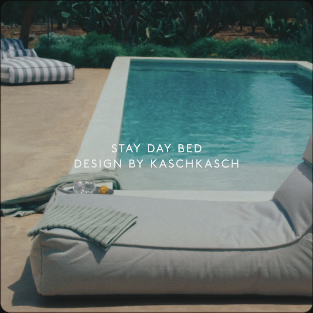 Poolside daybed with light gray cushions