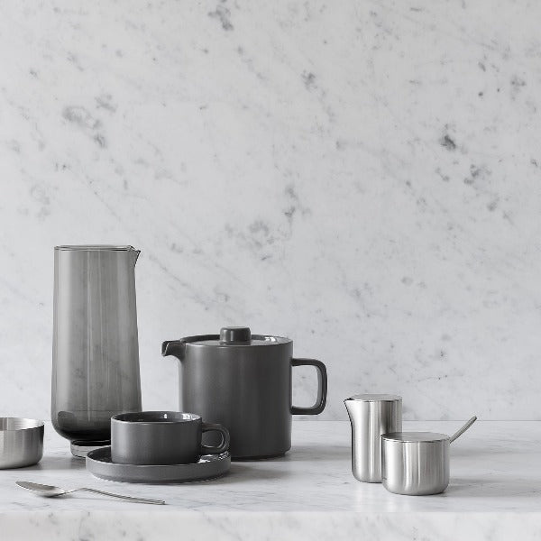 marble counter and backsplash featuring a tea set and blomus BASIC cream and sugar containers