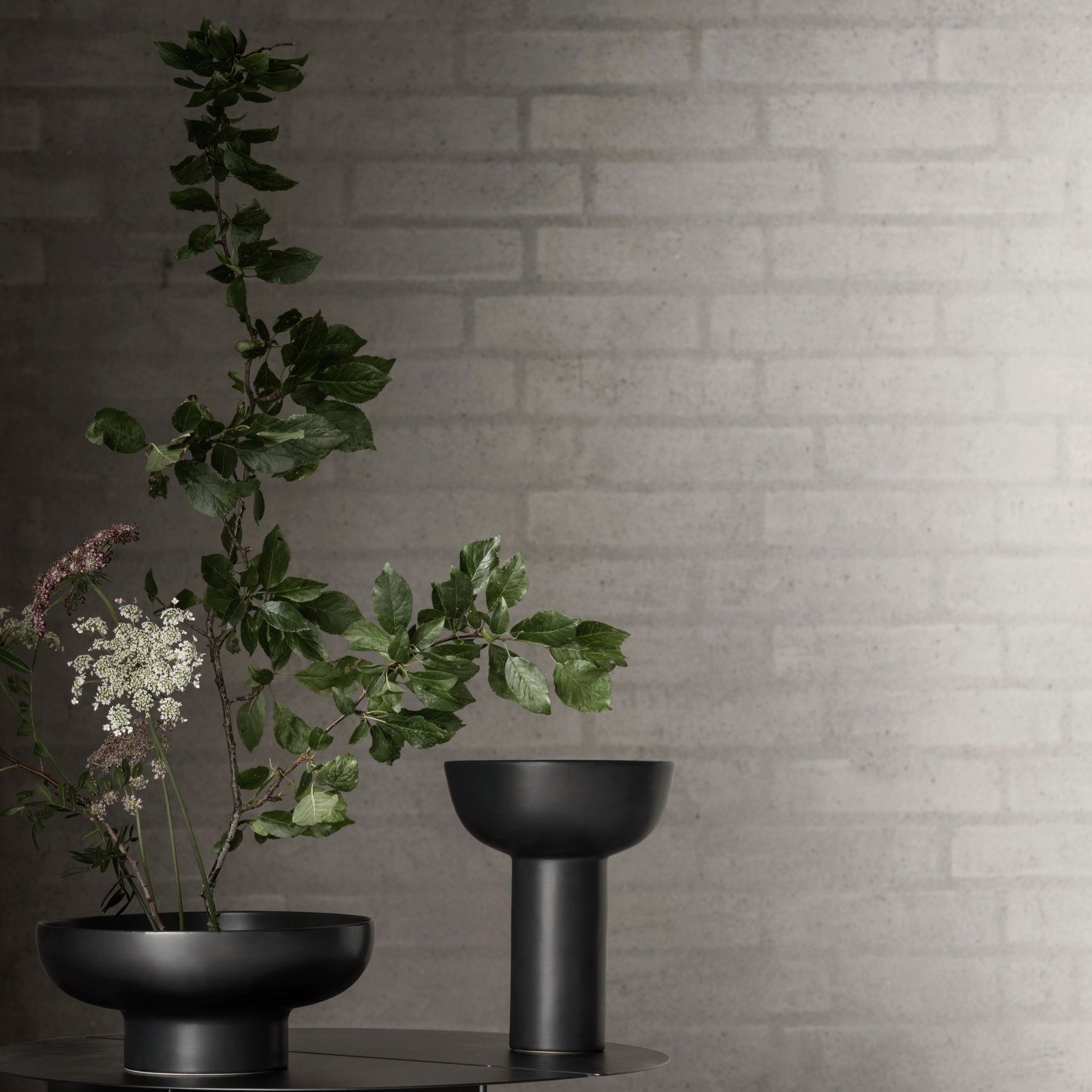 black Japanese inspired MIYABI vases by blomus in front of simple white brick wall