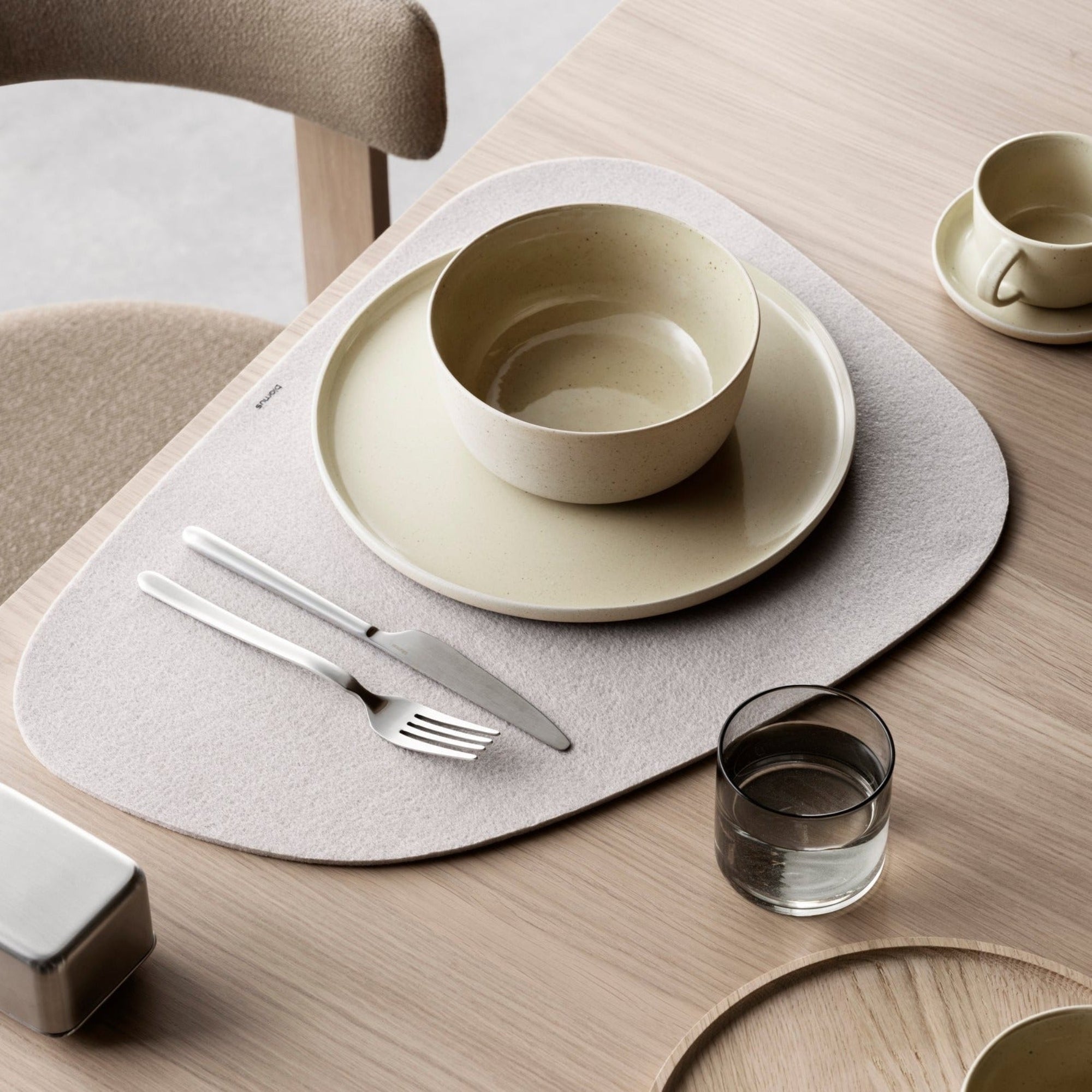 modern dining table place setting by blomus with Savannah color SABLO stoneware on a felt placemat