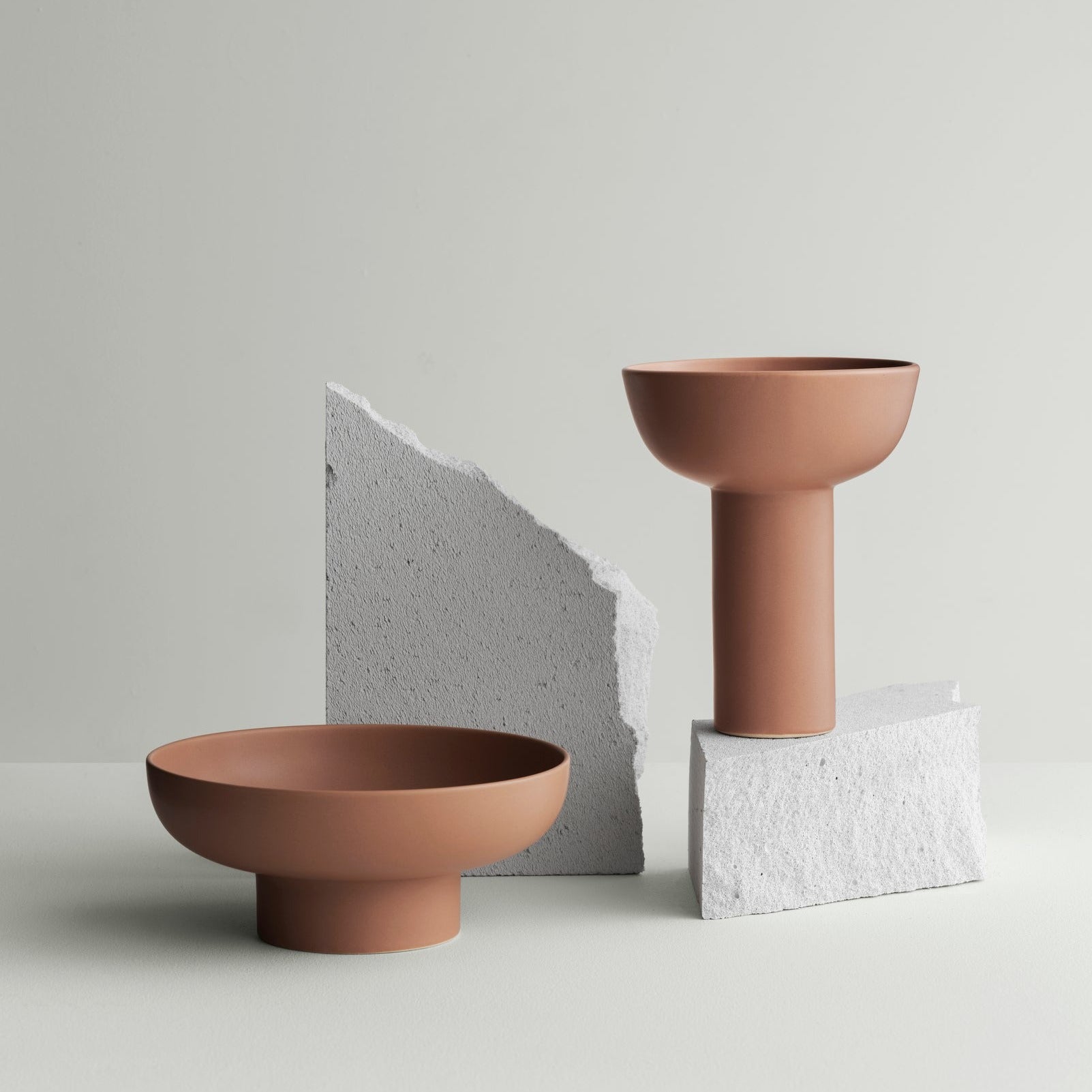 Terracotta  colored ceramic vases from blomus MIYABI collection arranged on broken stone
