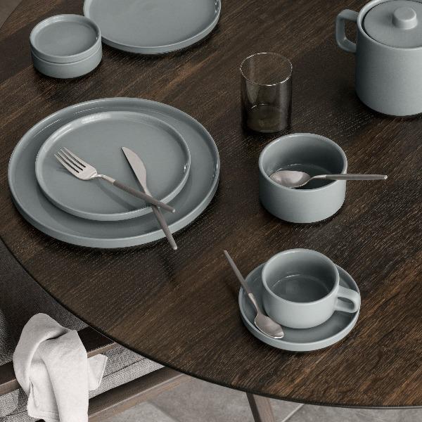 Scandinavian inspired PILAR dishware by blomus in mirage grey glaze arranged on a modern minimalist wooden table for a sophisticated meal