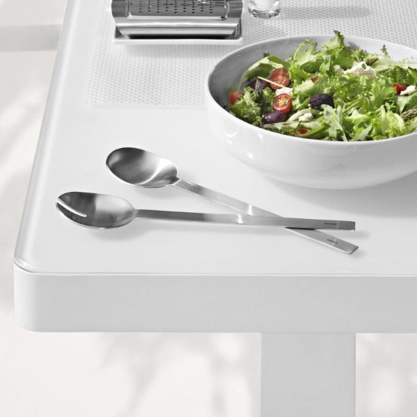 blomus EASY brushed stainless salad servers next  to salad bowl on a clean white table with minimalist aesthetic