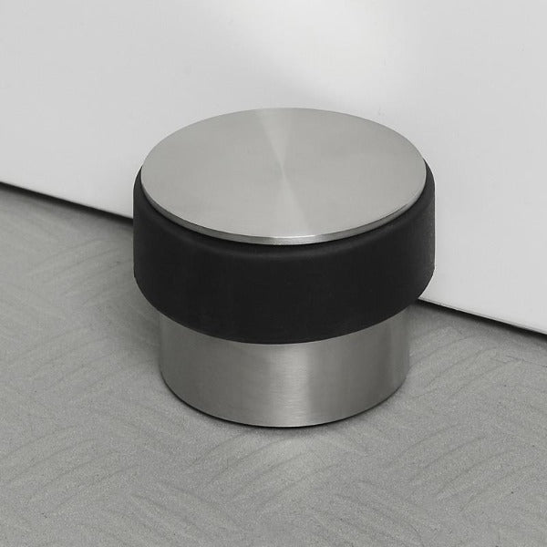 STOP Brushed stainless doorstop with rubber ring on textured floor by blomus