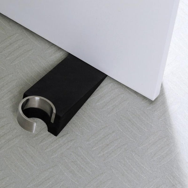 Wedge Door Stop under a white door on industrial floor