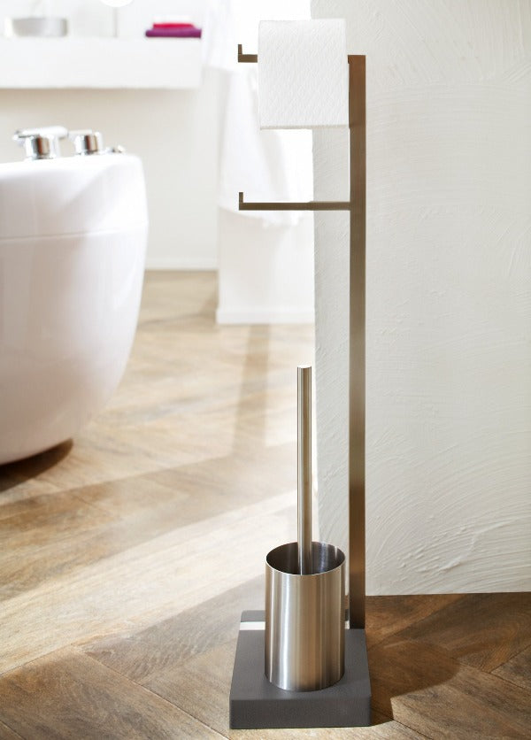 Brushed stainless toilet accessory stand with brush in a modern simplistic bathroom