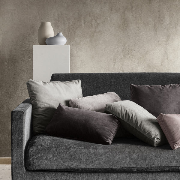 cozy couch with pedestal behind displaying modern COLORA vase by blomus